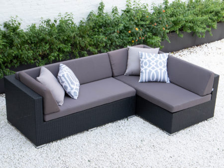 Small L sectional in dark grey cushions
